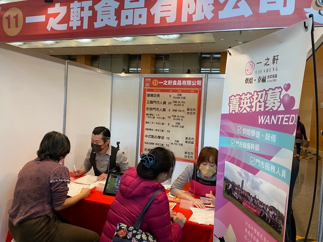 在就業博覽會的一之軒攤位面試求職者，旁邊是「菁英招募 WANTED」的職缺看板